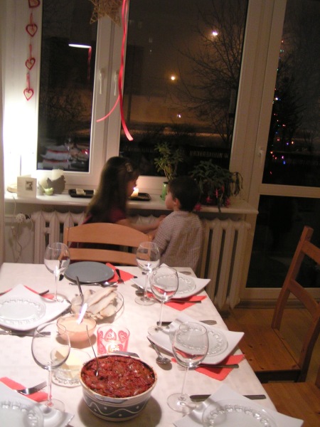 Poland: children looking for the 'First Star' to appear on the sky and a Christmas Eve supper waiting on a table.